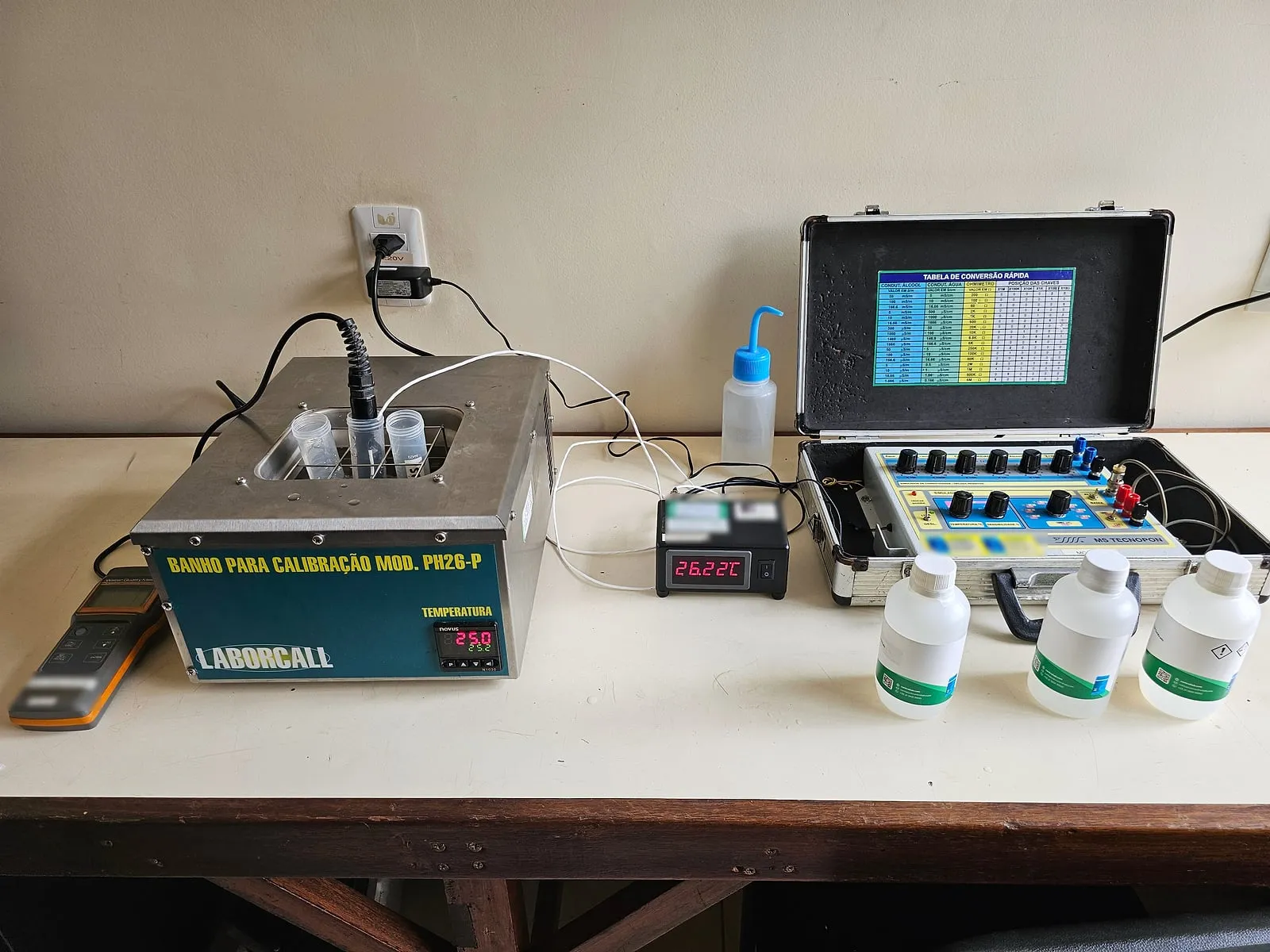 Bancada com banho termostático para calibração de pH, indicador de temperatura, simulador de condutividade e frascos de solução-padrão